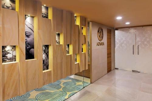 un vestíbulo con un pasillo con una puerta y una pared con cuadros en Barsana Boutique Hotel - Pure vegetarian en Calcuta