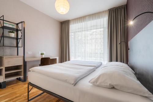 a bedroom with a white bed and a window at EA ApartHotel Melantrich in Prague