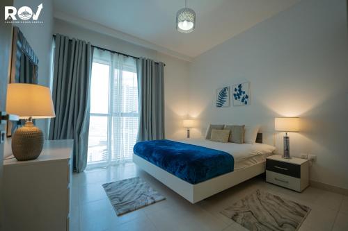 um quarto com uma cama e uma grande janela em Blissful 1BR with Pool and Creek view em Dubai