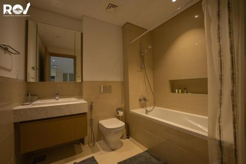 uma casa de banho com um lavatório, um WC e uma banheira em Blissful 1BR with Pool and Creek view em Dubai