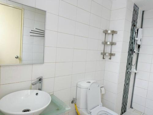 een badkamer met een wastafel, een toilet en een spiegel bij JB City Sunset Studio Paradigm Sutera & UTM Wifi 4pax in Johor Bahru