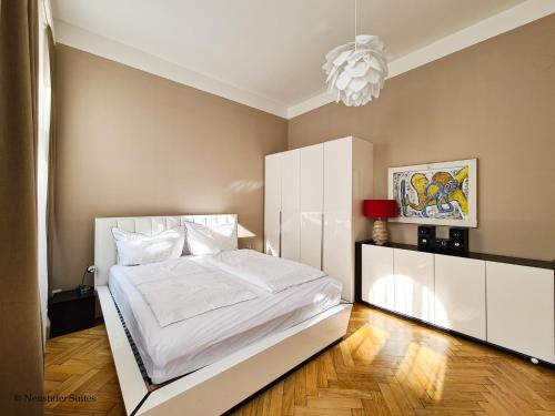 a bedroom with a white bed and a chandelier at Appartement Cervantes 9 in Vienna