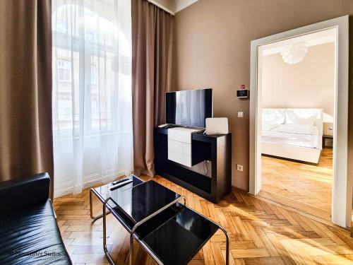 a living room with a tv and a couch and a bed at Appartement Cervantes 9 in Vienna
