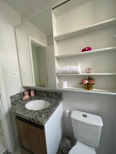 a bathroom with a sink and a toilet and a mirror at Belíssimo apartamento inteiro in Aracaju