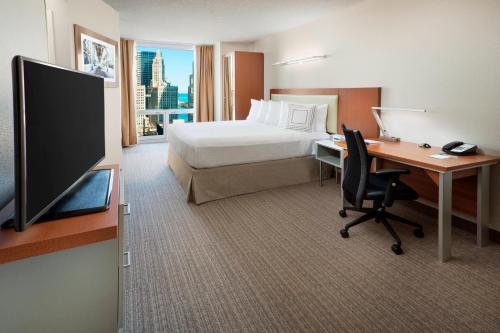 a hotel room with a bed and a desk and a television at SpringHill Suites Chicago Downtown/River North in Chicago