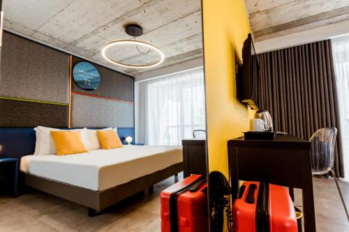 una habitación de hotel con una cama y una maleta en IKYK Hotel- IK Collection en San Julián