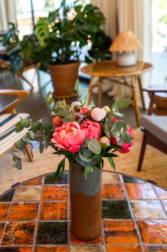 a vase filled with pink flowers on a table at Les Terrasses du Bailli in Rayol-Canadel-sur-Mer