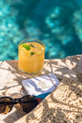 a drink in a glass bowl next to a swimming pool at Hôtel Le Bailli De Suffren in Rayol-Canadel-sur-Mer
