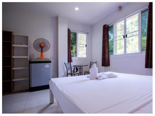 a bedroom with a bed and a table and chairs at Namhasin House in Koh Tao