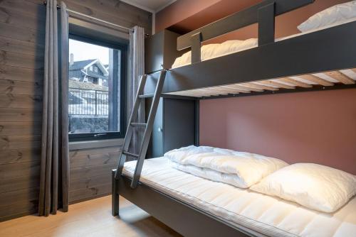 a bedroom with two bunk beds and a window at Riddertunet apartment 104 - in the center of Beitostølen in Beitostøl