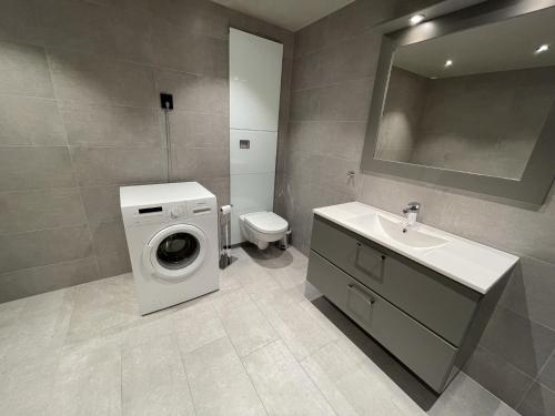 a bathroom with a washing machine and a sink at Riddertunet apartment 104 - in the center of Beitostølen in Beitostøl