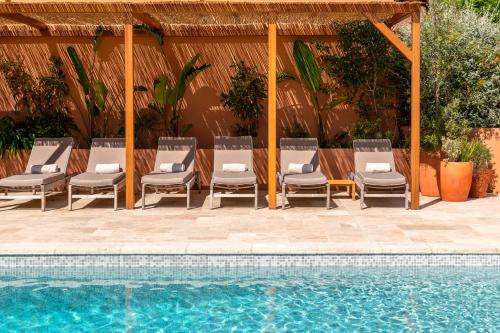 un grupo de sillas sentadas junto a una piscina en Les Terrasses du Bailli en Rayol-Canadel-sur-Mer