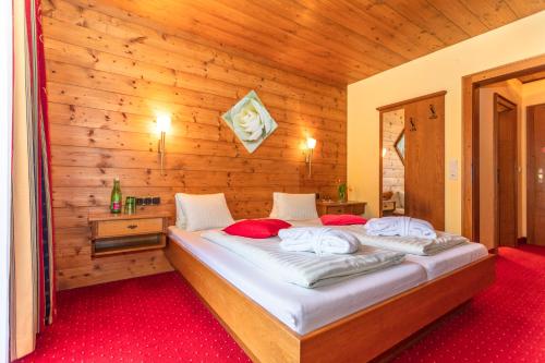 a bedroom with two beds in a wooden wall at Hotel Wenger Alpenhof in Werfenweng