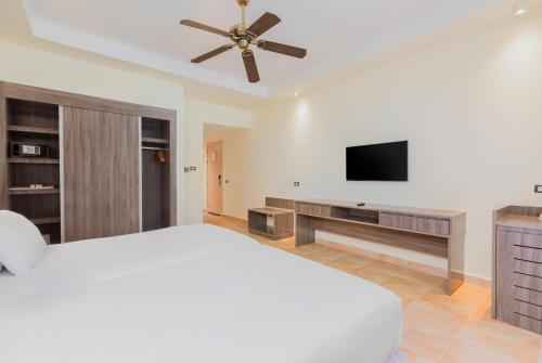 a bedroom with a bed and a flat screen tv at Pickalbatros Jungle Aqua Park - Neverland Hurghada in Hurghada