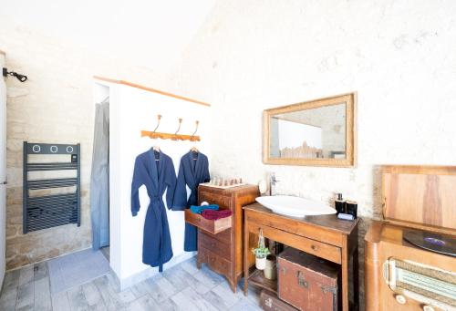 uma casa de banho com um lavatório e um espelho em L'Eden chambre d'hôtes avec jacuzzi et massages em Saint-Aubin-la-Plaine