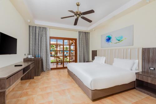 a bedroom with a bed and a flat screen tv at Pickalbatros Jungle Aqua Park - Neverland Hurghada in Hurghada