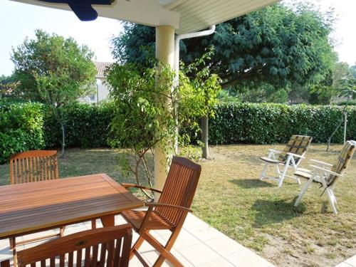 - un ensemble de chaises et une table en bois sur la terrasse dans l'établissement Arbousiers - Seignosse agréable villa contemporaine, à Seignosse