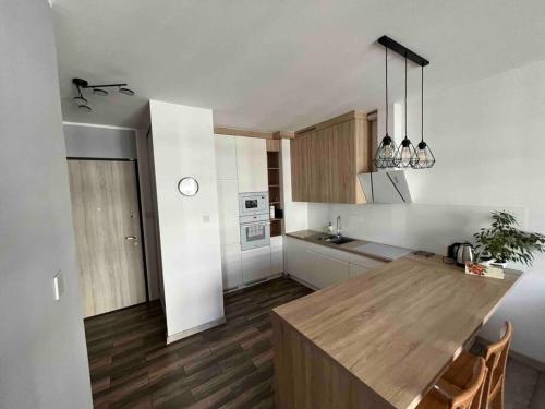 a kitchen with a wooden table in a room at Apartament Letnica in Gdańsk
