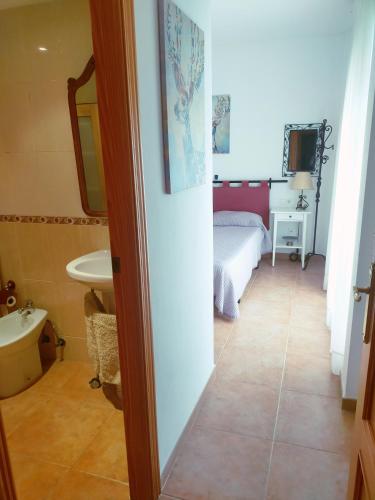 a bathroom with a bed and a sink in a room at Casa Edén in Cullera