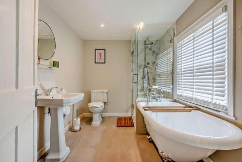 a bathroom with a tub and a sink and a toilet at Molls Yard in Chipping Norton