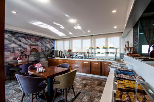 a restaurant with a table and chairs and a kitchen at Lapis Inn Hotel & Spa ( Ex. Ambassador Hotel) in Istanbul