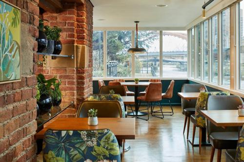 a restaurant with tables and chairs and a brick wall at Manchester Marriott Victoria & Albert Hotel in Manchester