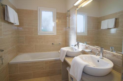 a bathroom with a tub and a sink and a bath tub at Villa Asteri, Old Skala - Secluded Location - Panoramic Sea Views - Infinity Pool in Old Skala