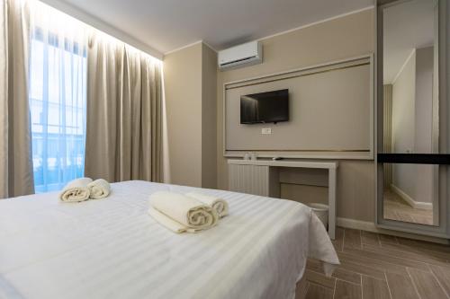 a hotel room with a bed with towels on it at DelSool MAMAiA in Mamaia