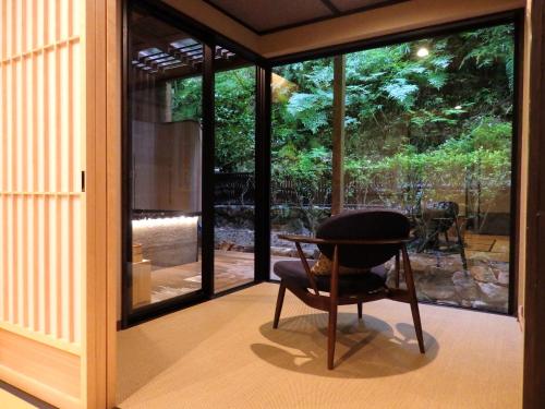 a room with a chair in front of a window at Ryokan Sumiya Kihoan in Kameoka