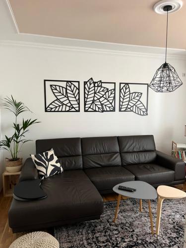 a living room with a black leather couch at Apartment Ema in Novi Sad