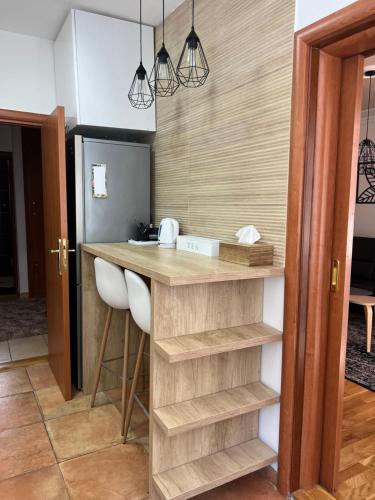 a kitchen with a wooden counter with two stools at Apartment Ema in Novi Sad