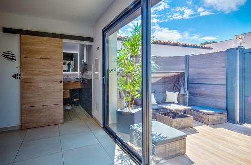 a room with a balcony with a glass wall at L'OLYMPE DES SENS in Portiragnes