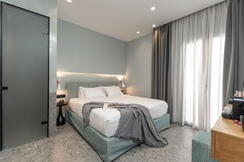 a bedroom with a bed and a large window at Argo Boutique Hotel in Naxos Chora