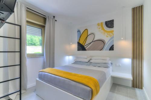 a white bedroom with a bed and a window at Kika's Home in Križišće