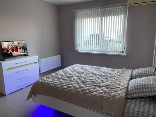 a bedroom with a bed and a dresser and a television at New 2 bedroom apartment 71 m in Odesa