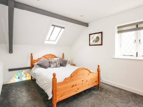 sypialnia z drewnianym łóżkiem w pokoju z białymi ścianami w obiekcie Richrose Chapel w mieście Spalding