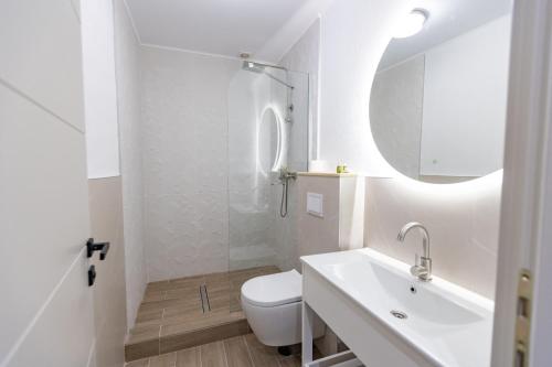 a bathroom with a toilet and a sink and a mirror at DelSool MAMAiA in Mamaia