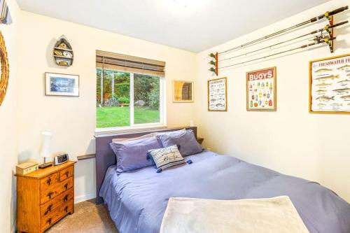 a bedroom with a blue bed and a window at Seal Rock Cottage in Brinnon