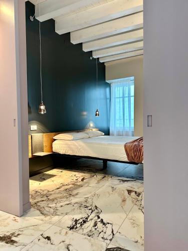 a bedroom with a bed in a room with blue walls at Vulcano Palace in Castro