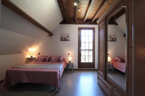 1 dormitorio en el ático con cama y ventana en Le cailhabas, en Lescun