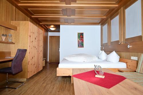 um quarto com uma cama, uma secretária e uma cadeira em DZ Komfort em Biberwier