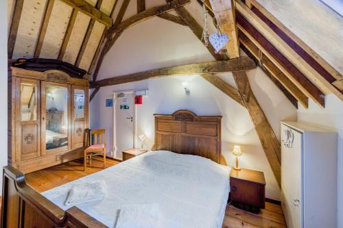 ein Schlafzimmer mit einem großen Bett in einem Zimmer mit Holzdecken in der Unterkunft Meschermolen 12 in Eijsden