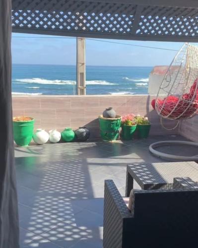 un gruppo di piante seduti su un balcone con vista sull'oceano di Beachfront Villa Darbouazza a Dar Bouazza