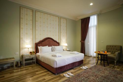 Savoy Hotel ELMinya في المنيا: غرفة نوم بسرير ابيض كبير وكرسي