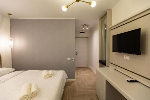 a hotel room with two towels on a bed and a television at DelSool Mamaia in Mamaia