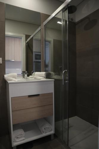 a bathroom with a sink and a glass shower at MEU STUDIO in Gandra