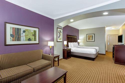 a hotel room with a bed and a couch at La Quinta by Wyndham Cleburne in Cleburne