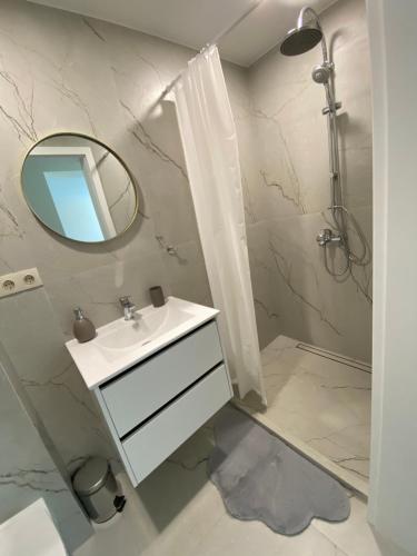 W łazience znajduje się umywalka i lustro. w obiekcie Baltic Avenue w Kłajpedzie