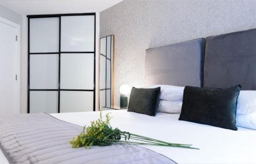 a bedroom with a large white bed with black pillows at Oxford Street Fitzrovia Apartments in London
