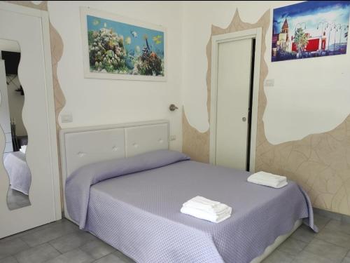 - une chambre dotée d'un lit avec des draps violets dans l'établissement Elis...land..., à Torre Canne